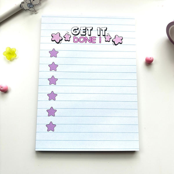 Straight-on view of the Get It Done checklist notepad with pink stars, flanked by a washi tape roll and pink and yellow decorative beads