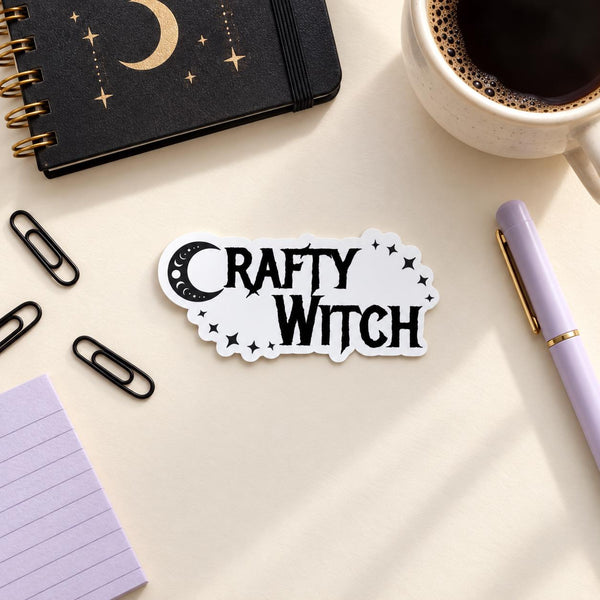 Crafty Witch die-cut sticker with black gothic lettering, crescent moon and stars