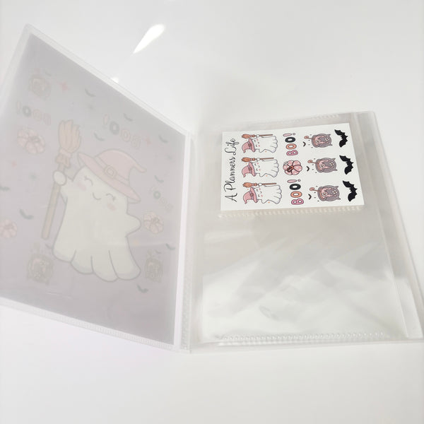 Spooky-cute ghost sticker storage binder opened to show a clear sleeve page holding a small Halloween sticker sheet